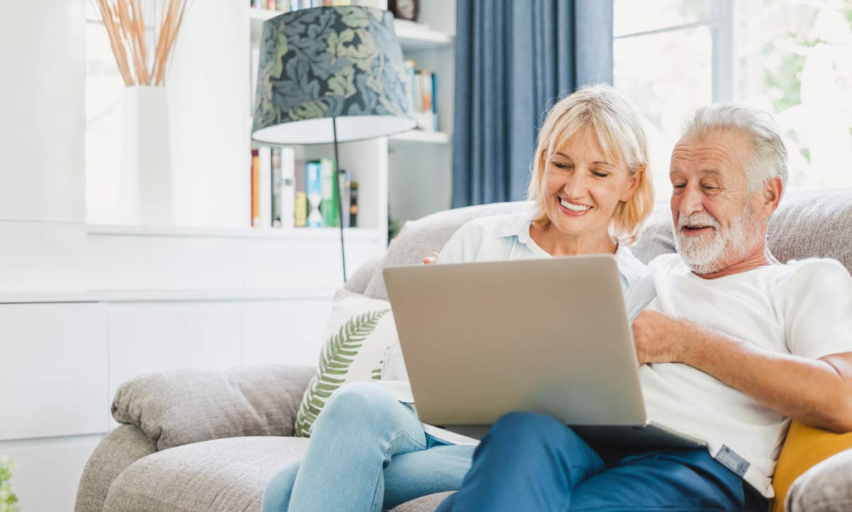 an older couple looking at a computer at home