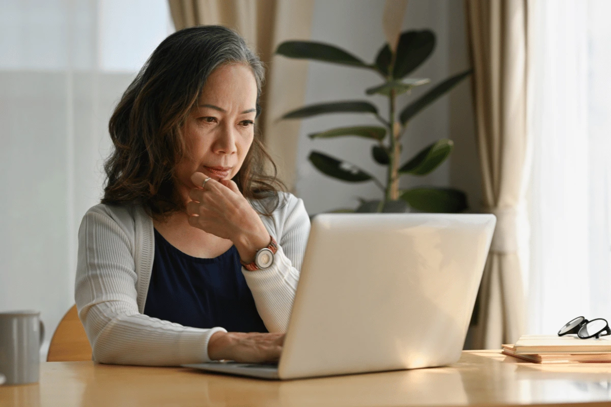an older woman looking at her computer at home